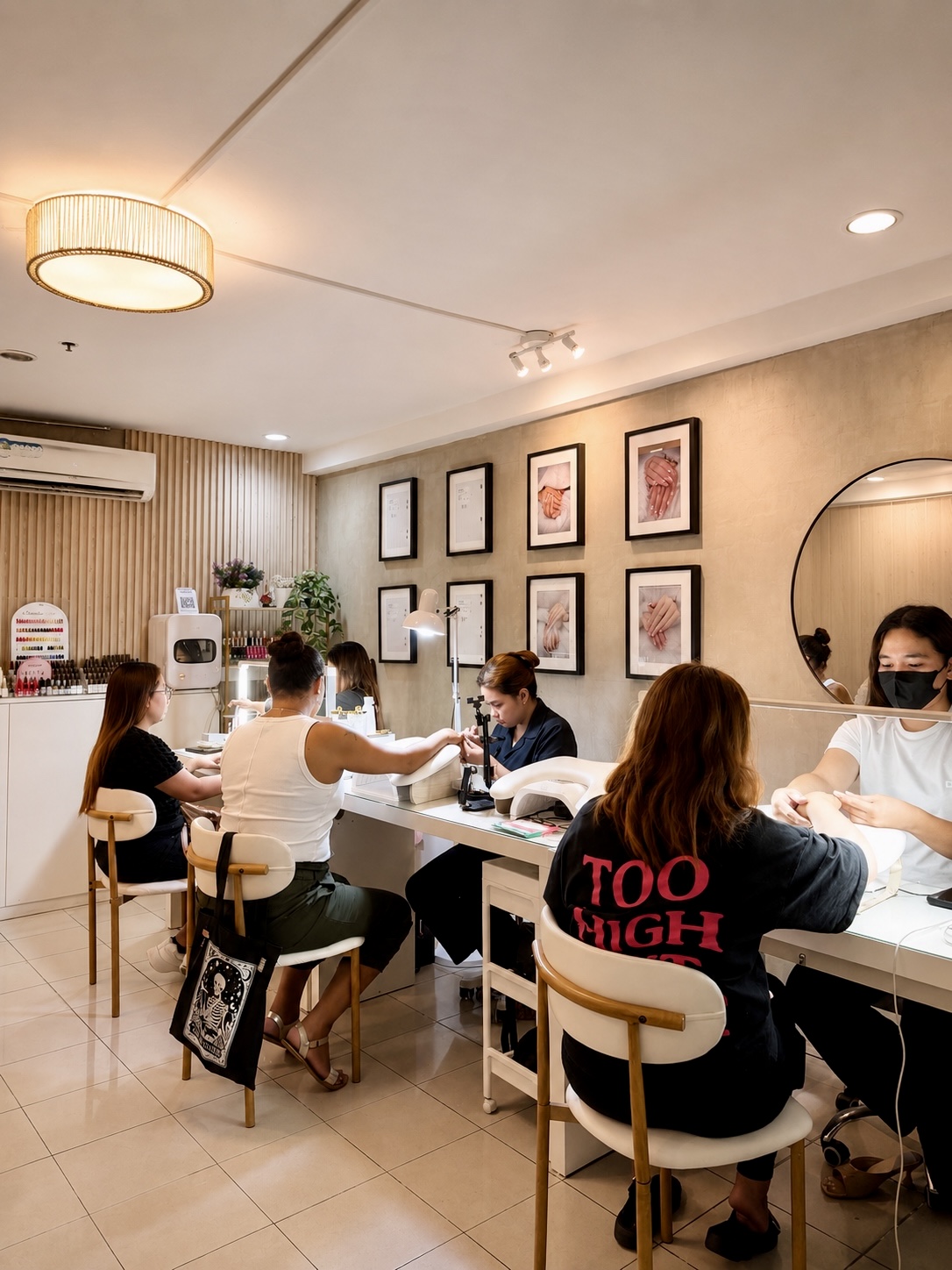 full view of AyuriNails Beauty Lounge nail salon with clients being served, framed nail art on the wall, Poblacion Makati